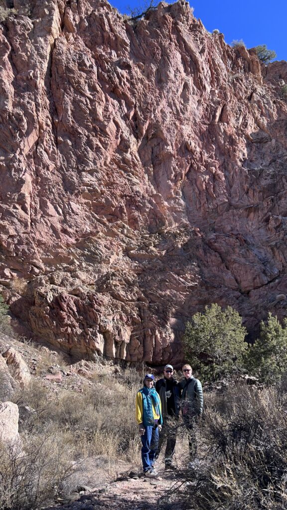 Route developers pose for photo op before a red cliff in the badlands of Cundiyo.